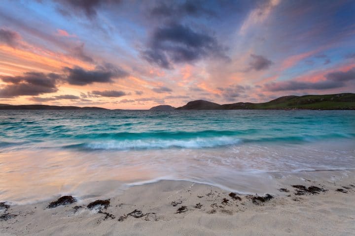 Colorful dawn on a white sandy beach . Isle of Vatersay, Outer Hebrides, Scotland.