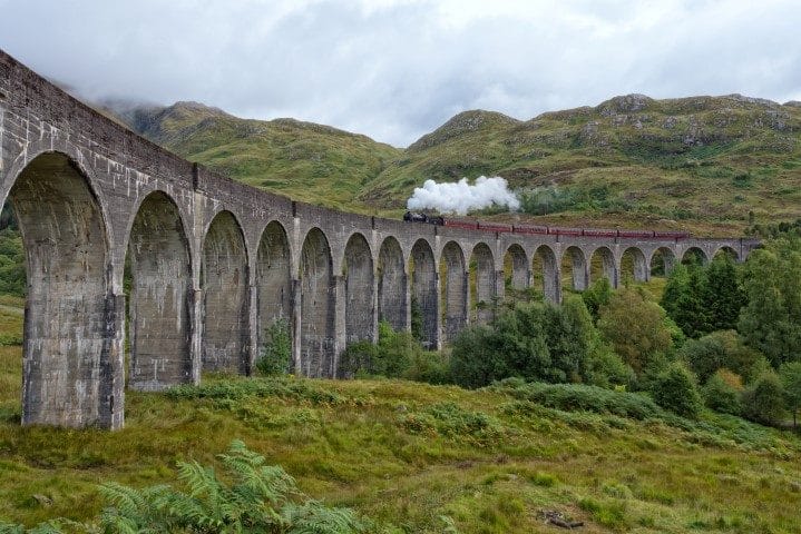 Jocobite steam train crossing the Glenfinnan railway viaduct in Scotland